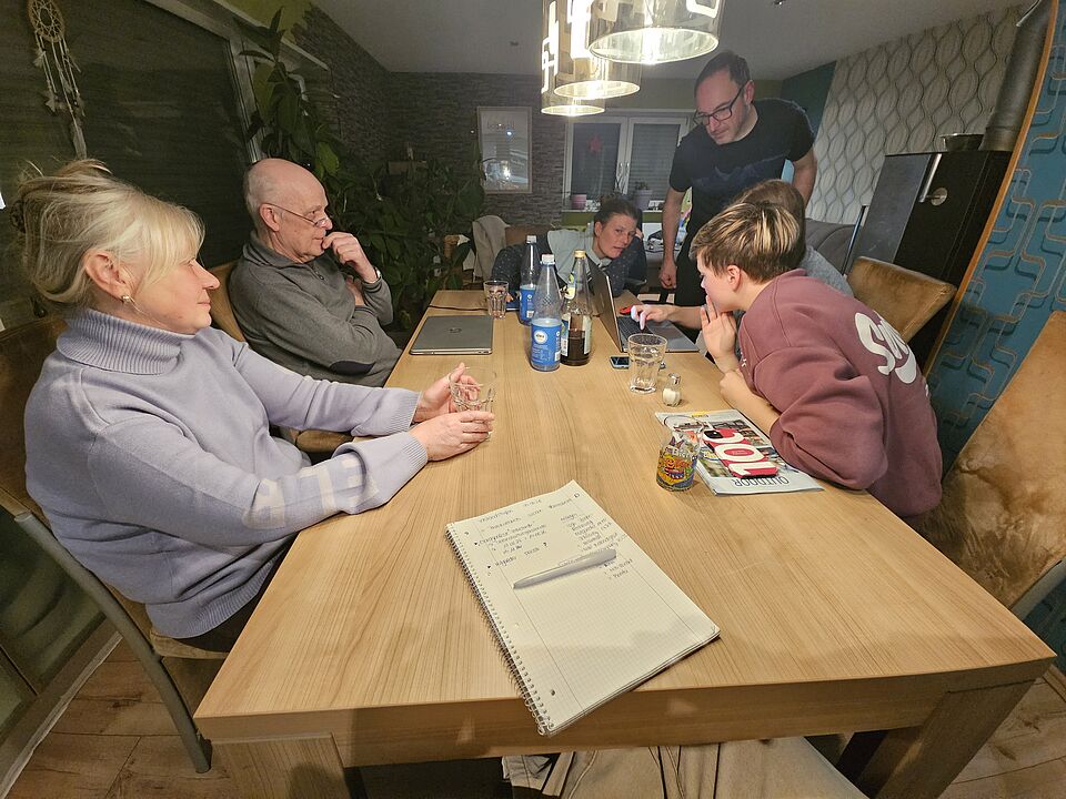 mehrere Personen sitzen am Tisch und diskutieren